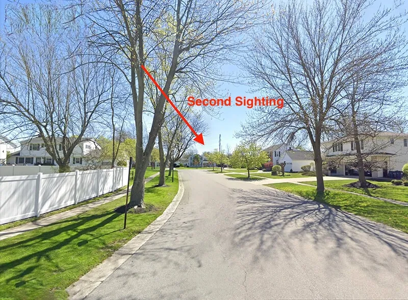 A tree-lined street with an arrow marking where the second sighting happened